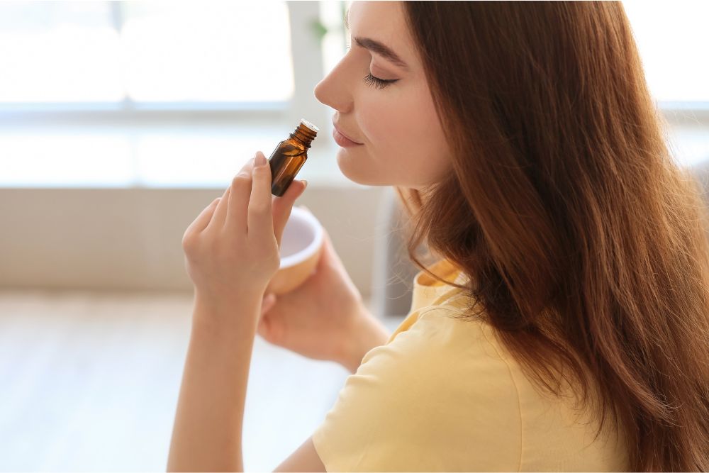 Vrouw ontspant met etherische oliën en een diffuser in een gezellige omgeving