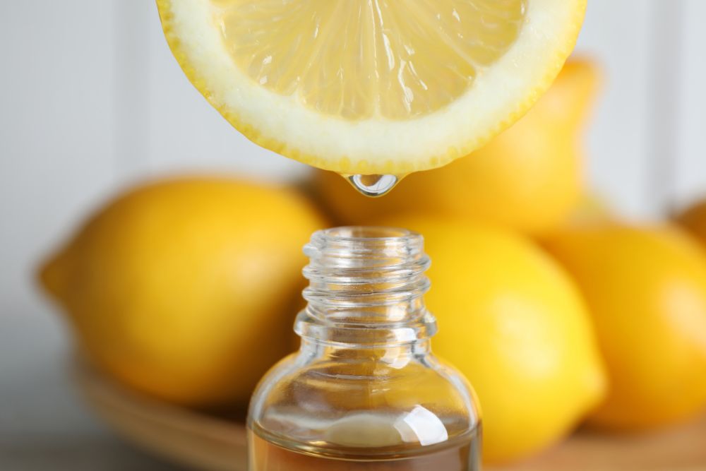 Citroensap druppelt in een flesje – citrusoliën kunnen fotosensibiliserend zijn.