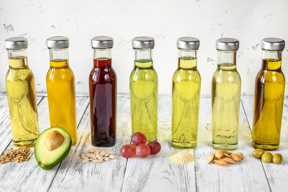 Verschillende soorten natuurlijke basisoliën in flesjes – avocado, druivenpitten, olijven en andere grondstoffen