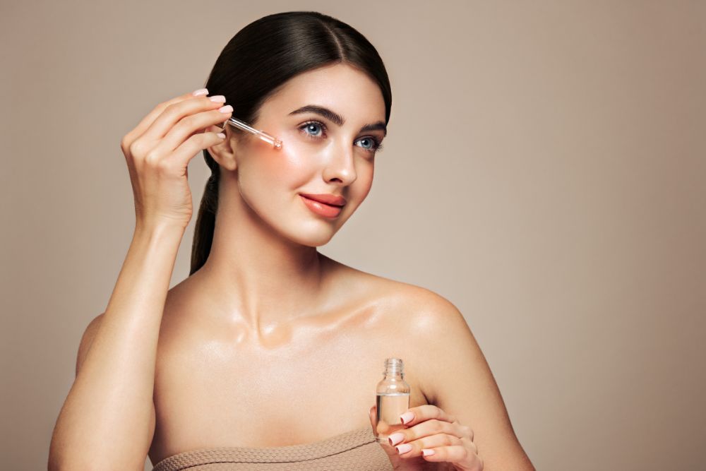 Vrouw brengt een natuurlijk gezichtsserum met etherische oliën aan op het gezicht