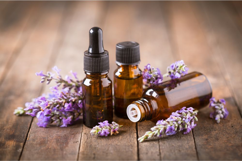 Flesjes met etherische lavendelolie en lavendelbloemen op een houten tafel – natuurlijke cosmetica.